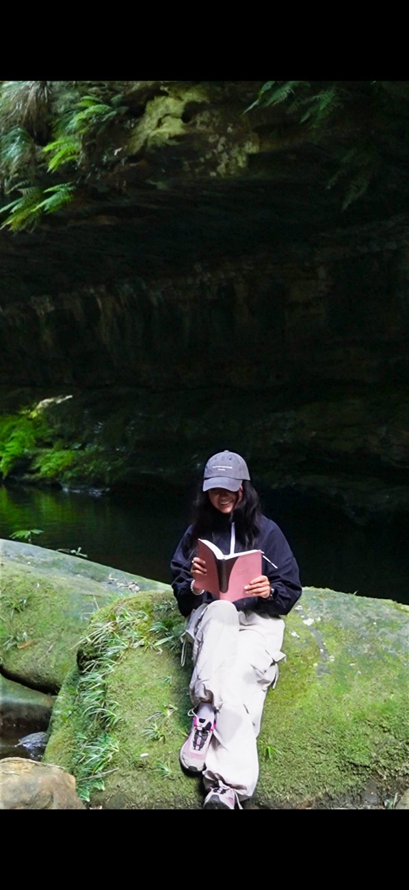 Brooke reading during a rainforest adventure