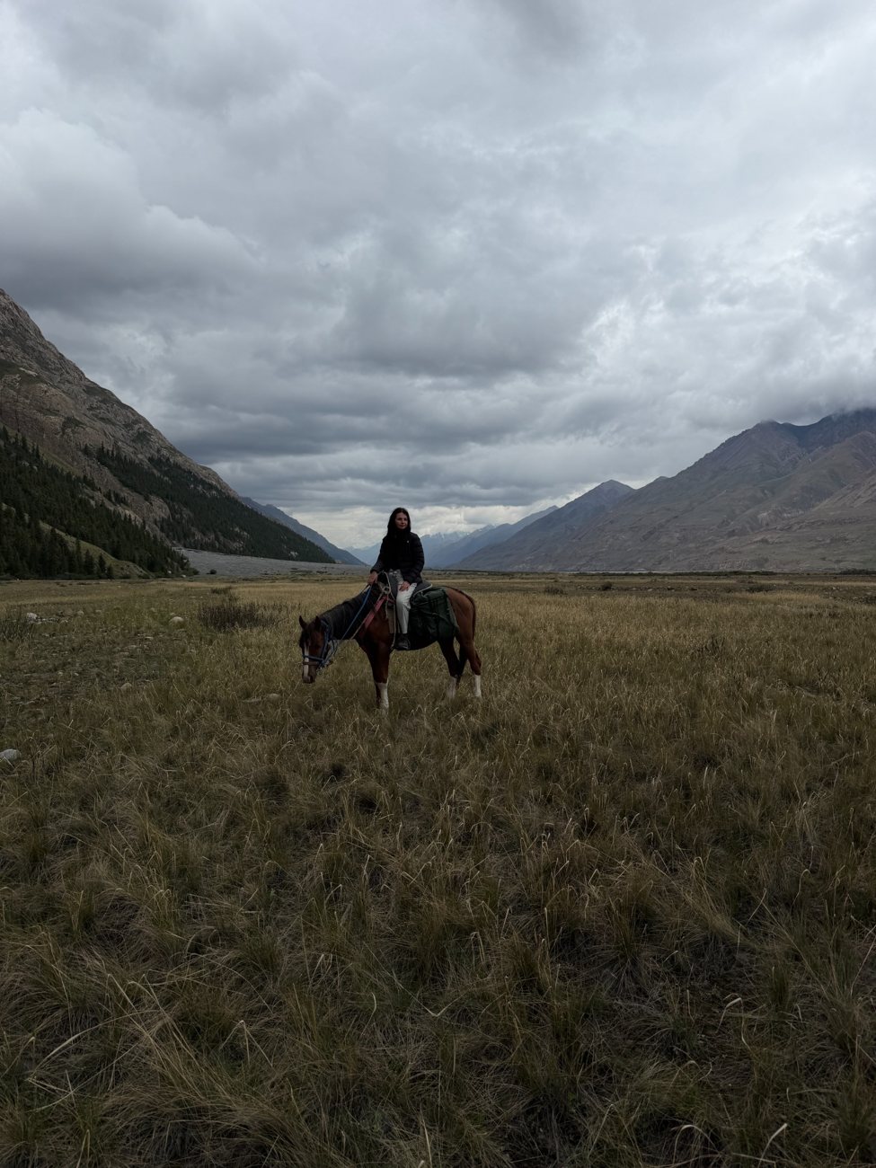 Brooke riding through rugged mountains